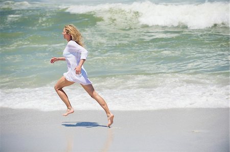 running to surf - Side profile of a beautiful woman running on the beach Foto de stock - Sin royalties Premium, Código: 6108-05870871