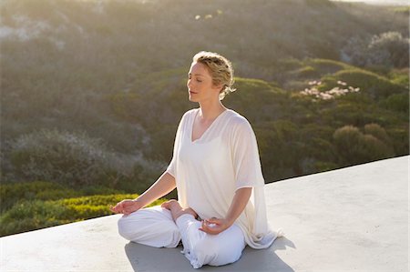 sitting on terrace - Mid adult woman meditating Stock Photo - Premium Royalty-Free, Code: 6108-05870880