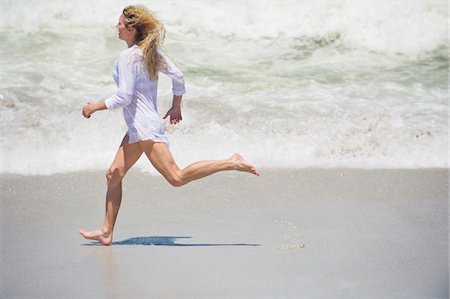 running to surf - Side profile of a beautiful woman running on the beach Foto de stock - Sin royalties Premium, Código: 6108-05870886