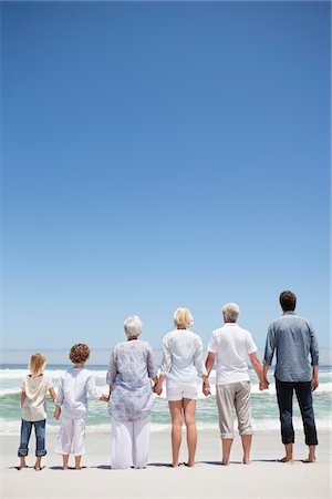 simsearch:6108-05875021,k - Vue arrière d'une famille en regardant la vue sur la mer de la plage Photographie de stock - Premium Libres de Droits, Code: 6108-05870822