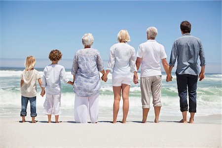 Vue arrière d'une famille en regardant la vue sur la mer de la plage Photographie de stock - Premium Libres de Droits, Code: 6108-05870827