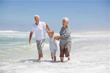 surf (waves hitting shoreline) - Granddaughter enjoying with grandparents on beach Foto de stock - Sin royalties Premium, Código: 6108-05870824