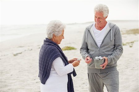 Senior couple collecting shell on the beach Stock Photo - Premium Royalty-Free, Code: 6108-05870959