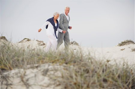 simsearch:6108-06906865,k - Senior couple walking on the beach Stock Photo - Premium Royalty-Free, Code: 6108-05870963