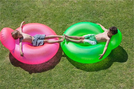 Two boys relaxing on inflatable rings Foto de stock - Sin royalties Premium, Código: 6108-05870919