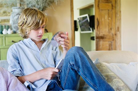 Cute little boy looking at compact disc Stock Photo - Premium Royalty-Free, Code: 6108-05871072