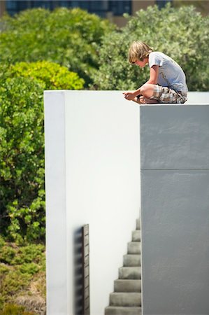 sitting on terrace - Teenage boy sitting at the edge of a terrace Stock Photo - Premium Royalty-Free, Code: 6108-05871096