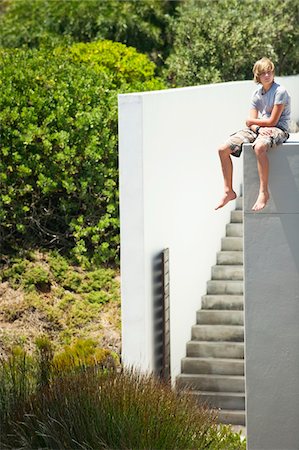 edging - Teenage boy sitting at the edge of a terrace Stock Photo - Premium Royalty-Free, Code: 6108-05871105