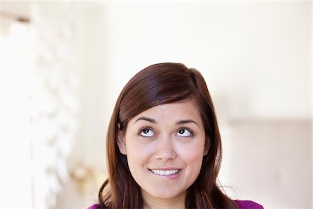 playful - Young woman looking away while biting lips Stock Photo - Premium Royalty-Free, Code: 6108-05871138