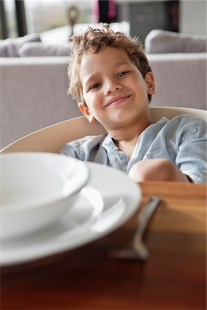 Portrait of a boy sitting at a dining table Stock Photo - Premium Royalty-Free, Code: 6108-05871231