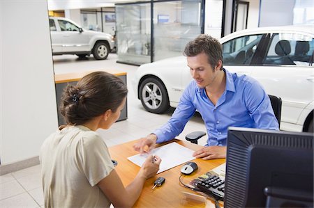 selling car - Mid adult man buying car in a showroom Stock Photo - Premium Royalty-Free, Code: 6108-05871379