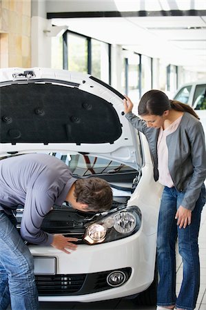 Couple looking at car engine in showroom Foto de stock - Sin royalties Premium, Código: 6108-05871397