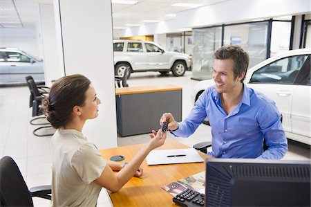 sala de exhibición - Saleswoman handling car key to a man Foto de stock - Sin royalties Premium, Código: 6108-05871399