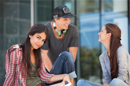 Portrait of a woman sitting with her friends looking at each other Stock Photo - Premium Royalty-Free, Code: 6108-05871308