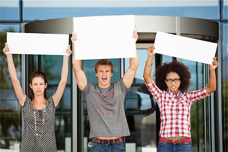 Angry friends protesting with blank placards Stock Photo - Premium Royalty-Free, Code: 6108-05871339