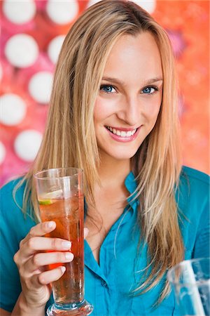 simsearch:6108-06166197,k - Portrait of a beautiful woman having ice tea in a bar and smiling Foto de stock - Sin royalties Premium, Código: 6108-05871456