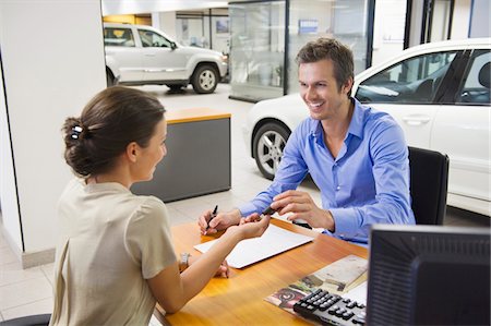 selling - Young woman handing car key to a man Stock Photo - Premium Royalty-Free, Code: 6108-05871408