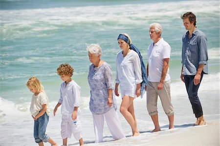 people walking in line side view - Multi generation family walking in a line on the beach Stock Photo - Premium Royalty-Free, Code: 6108-05871526