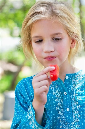 simsearch:6108-05869472,k - Close-up of a cute girl eating fruit outdoors Stock Photo - Premium Royalty-Free, Code: 6108-05871661