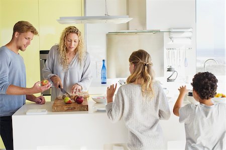 simsearch:6108-05871667,k - Couple with their two children preparing food at a domestic kitchen Stock Photo - Premium Royalty-Free, Code: 6108-05871674