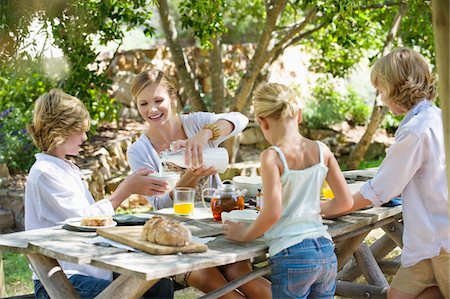 family sitting at table - Family having food at front or back yard Stock Photo - Premium Royalty-Free, Code: 6108-05871675