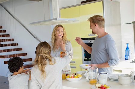 family with milk - Couple with their two children preparing food at a domestic kitchen Stock Photo - Premium Royalty-Free, Code: 6108-05871691