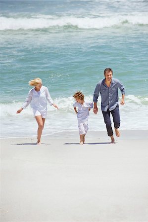 simsearch:6108-05871624,k - Couple with their son running on the beach Foto de stock - Royalty Free Premium, Número: 6108-05871605