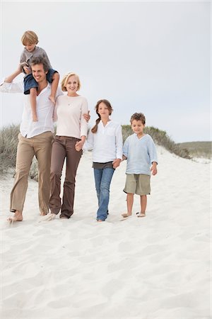 simsearch:6108-06907583,k - Couple walking on the beach with their children Stock Photo - Premium Royalty-Free, Code: 6108-05871632