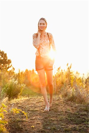 Beautiful woman walking on a trail and smiling Stock Photo - Premium Royalty-Free, Code: 6108-05871893