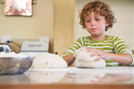 simsearch:6108-06907097,k - Cute little boy kneading dough at kitchen Stock Photo - Premium Royalty-Free, Code: 6108-05871829