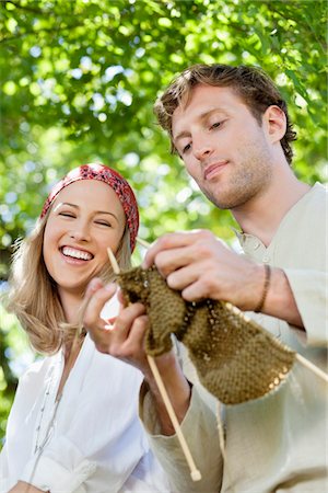 Young couple knitting together and smiling Stock Photo - Premium Royalty-Free, Code: 6108-05871836