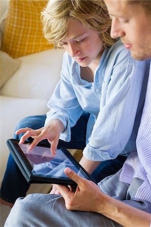 Man and a little boy looking at digital tablet Stock Photo - Premium Royalty-Free, Code: 6108-05872057
