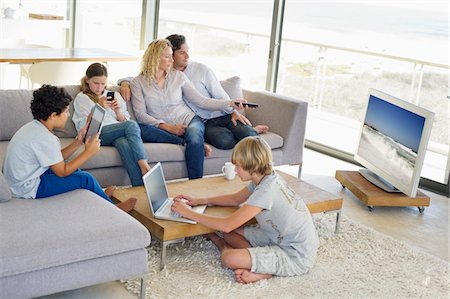 simsearch:6108-06905760,k - Couple watching television set while their children busy in different activities Stock Photo - Premium Royalty-Free, Code: 6108-05872070