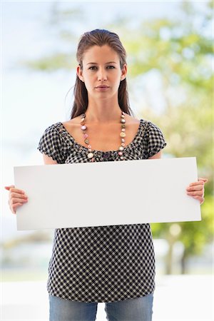 Portrait of a woman holding a blank placard Foto de stock - Sin royalties Premium, Código: 6108-05872151