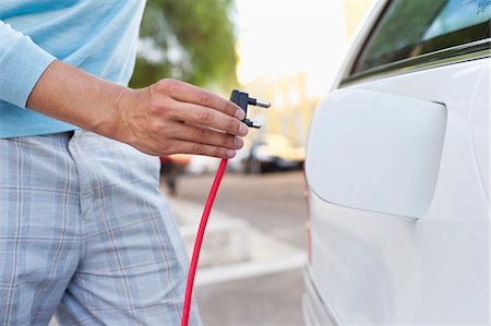 electricidad - Mid section view of a mid adult man charging the electric car Foto de stock - Sin royalties Premium, Código: 6108-05872180