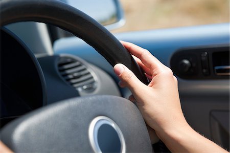 steering wheel - Close-up of a young woman's hand holding steering wheel Foto de stock - Sin royalties Premium, Código: 6108-05872182