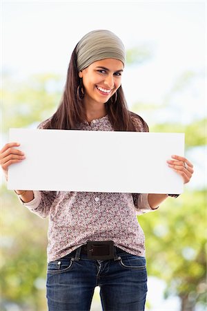 simsearch:6108-05871874,k - Portrait of a woman holding a blank placard Foto de stock - Sin royalties Premium, Código: 6108-05872135