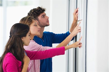 people looking at notice board - University students checking bulletin board for test result Foto de stock - Sin royalties Premium, Código: 6108-05872272