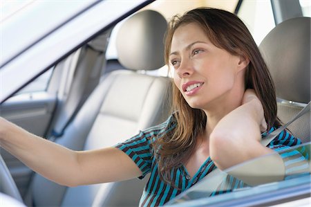seat - Tired young woman rubbing back of neck while driving a car Stock Photo - Premium Royalty-Free, Code: 6108-05872206