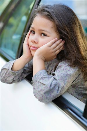 Cute little girl looking out of the car window Stock Photo - Premium Royalty-Free, Code: 6108-05872211