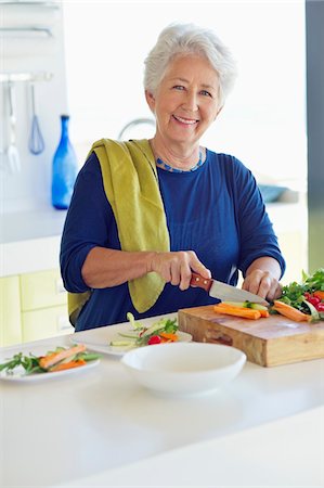 simsearch:6108-05871799,k - Portrait of a senior woman cutting vegetable in a kitchen Stock Photo - Premium Royalty-Free, Code: 6108-05872361