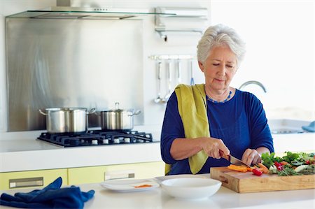 simsearch:6108-05871799,k - Senior woman cutting vegetable in a kitchen Stock Photo - Premium Royalty-Free, Code: 6108-05872376