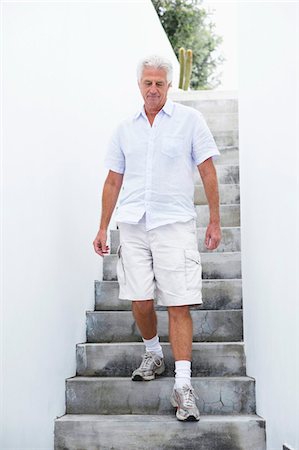 senior man introspective - Senior man getting down steps Stock Photo - Premium Royalty-Free, Code: 6108-05872386