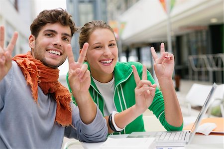 e-learning - Portrait of friends gesturing peace while using laptop Stock Photo - Premium Royalty-Free, Code: 6108-05872307