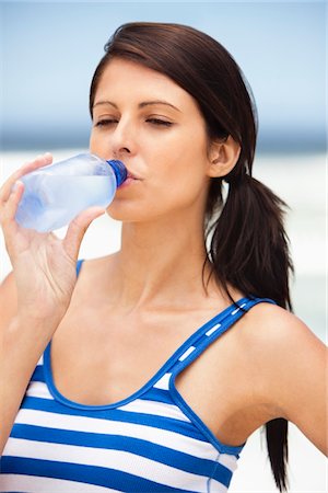drinking water - Close-up of a woman drinking water from a water bottle on the beach Stock Photo - Premium Royalty-Free, Code: 6108-05872493