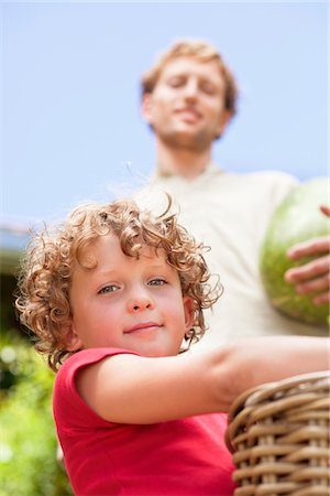 fruits basket low angle - Low angle view of father and son holding fruits Foto de stock - Sin royalties Premium, Código: 6108-05872582