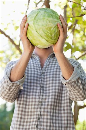 repollo - Man holding a cabbage in front of his face Foto de stock - Sin royalties Premium, Código: 6108-05872584
