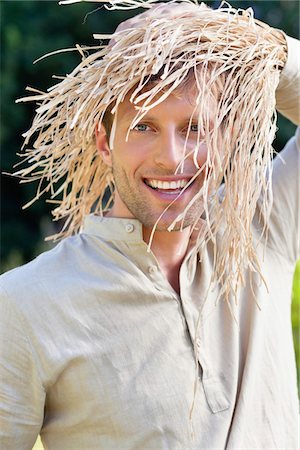 Portrait of a man standing in a field as scarecrow Stock Photo - Premium Royalty-Free, Code: 6108-05872594