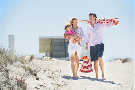 parasol de plage - Famille marchant sur la plage Photographie de stock - Premium Libres de Droits, Code: 6108-05872507