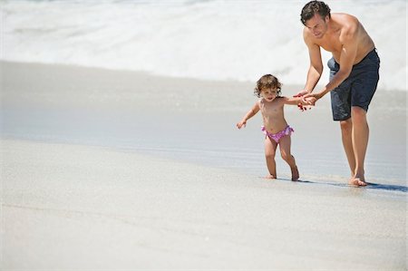 simsearch:6108-06166836,k - Father walking with little girl on the beach Foto de stock - Sin royalties Premium, Código: 6108-05872529